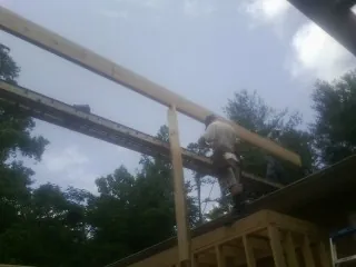 Carpenter setting a ridge beam over a new addition frame — Ice Dam Removal by Roofing Brothers in High Shoals
