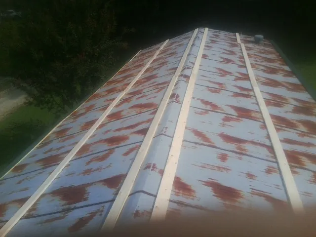 Rusted metal roof panels with new wood purlins before replacement — Storm Damage Roof Repair in High Shoals by Roofing Brothers