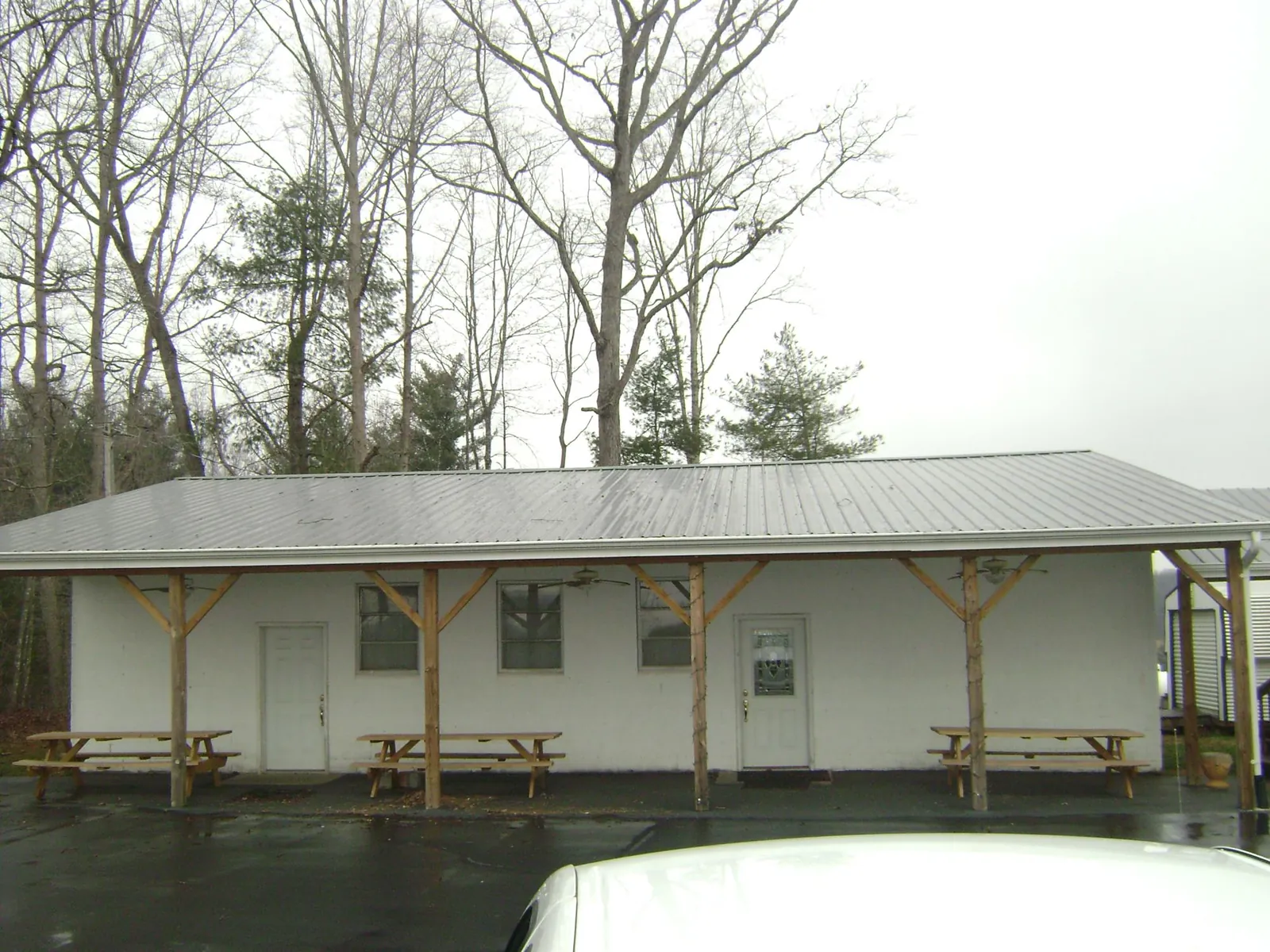 Gray metal roof over a block building with a timber post porch in High Shoals
